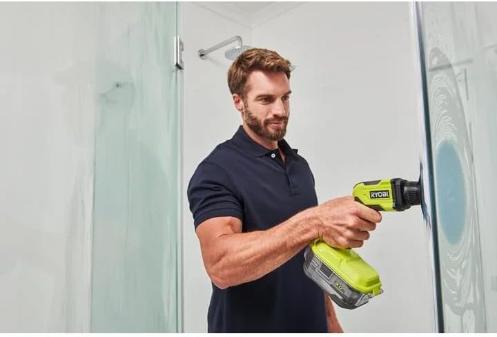 Man using a Ryobi tool on a glass shower door