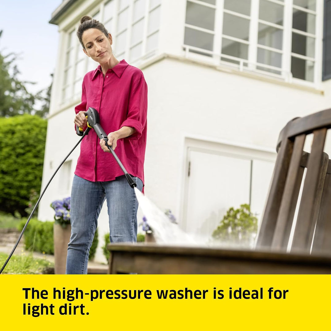 Woman using a high-pressure washer in front of a house