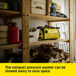Load image into Gallery viewer, Yellow compact pressure washer on a wooden shelf with tools and wood logs.
