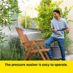 Load image into Gallery viewer, A man in a backyard is using a pressure washer on a wooden folding chair, with green plants and a house wall in the background. A yellow text banner at the bottom reads, 'The pressure washer is easy to operate.